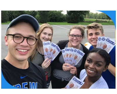 A group of young people smiling and holding campaign literature in their hands